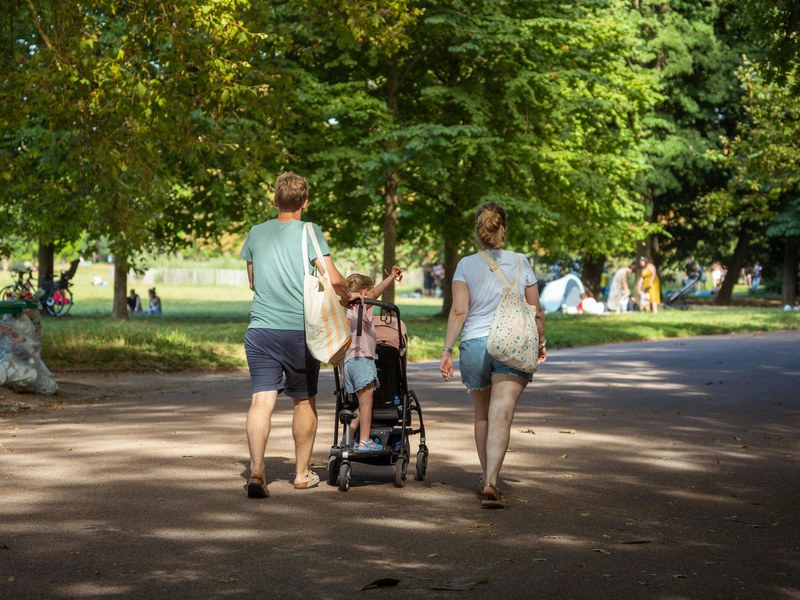Familia caminando por un parque arbolado